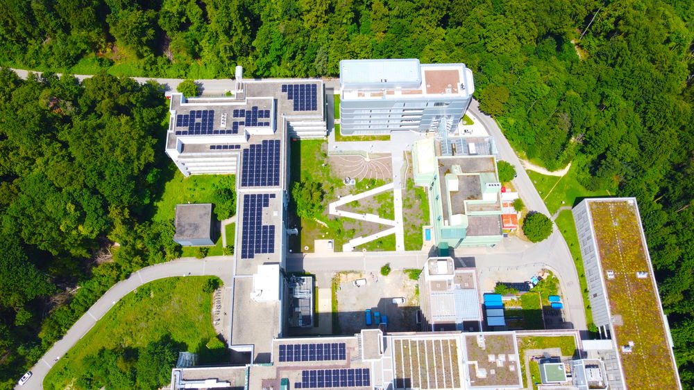 [Translate to Englisch:] Luftaufnahme zeigt die Dächer der Universität Konstanz mit Photovoltaikanlagen